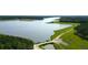 An aerial view of a lake surrounded by lush greenery and a path leading to a water access point at 149 Calm Water Way, Summerville, SC 29486