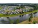 Beautiful aerial view of a home in a lakeside community surrounded by colorful homes and lush green trees at 149 Calm Water Way, Summerville, SC 29486