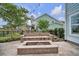 Well-maintained backyard featuring a stone fire pit, outdoor seating, and lush landscaping at 149 Calm Water Way, Summerville, SC 29486