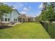 Beautiful backyard with a large grassy area, patio, screened porch, and well-maintained landscaping at 149 Calm Water Way, Summerville, SC 29486