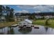 View of the community boat house providing access to a serene lake amid trees and nearby neighborhood homes at 149 Calm Water Way, Summerville, SC 29486