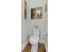 Cozy bathroom with a classic white toilet, wood floors, and artwork adorning the walls at 17 Trumbo St, Charleston, SC 29401