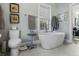 Bright bathroom with a free standing tub, gray tile, and neutral decor at 17 Trumbo St, Charleston, SC 29401