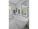 Modern bathroom featuring a freestanding tub, light gray tile floor, and bright natural light at 17 Trumbo St, Charleston, SC 29401