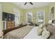 Light-filled bedroom features a large bed, a ceiling fan, and view of the neighborhood at 17 Trumbo St, Charleston, SC 29401