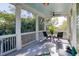 Outdoor porch featuring tall white columns and a small outdoor dining table with a view of the trees at 17 Trumbo St, Charleston, SC 29401