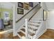 Hardwood staircase leads to the second floor, adorned with framed artwork and white banister at 17 Trumbo St, Charleston, SC 29401