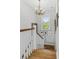 Staircase with white banister, chandelier, and a window letting in natural light at 17 Trumbo St, Charleston, SC 29401