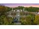 Stately home with a metal roof and multiple balconies, surrounded by lush trees at 186 N Shelmore Blvd, Mount Pleasant, SC 29464