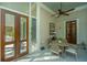Inviting screened porch featuring outdoor seating, a ceiling fan, and wood doors at 186 N Shelmore Blvd, Mount Pleasant, SC 29464