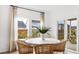 Bright dining area with a round table, modern chairs, large windows, and sliding doors leading to an outdoor patio at 200 Belfort Place, Summerville, SC 29486