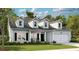 Charming home with a welcoming front porch, two-car garage, and dormer windows against a sunny, blue sky backdrop at 200 Belfort Place, Summerville, SC 29486