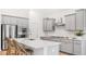 Stylish kitchen featuring an island with bar stool seating, stainless steel appliances, gray cabinetry, and white backsplash at 200 Belfort Place, Summerville, SC 29486