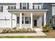 Inviting front porch with classic columns, ceiling fan, and manicured landscaping at 208 Evergreen Ave, Summerville, SC 29485