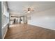 Open-concept living room with hardwood floors flowing into a kitchen with white cabinets and stainless steel appliances at 208 Evergreen Ave, Summerville, SC 29485