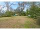 Large backyard featuring a playset, shed, mature trees, and healthy grass at 209 E 1St N St, Summerville, SC 29483