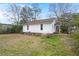 Expansive backyard with healthy lawn, mature trees, and classic white siding at 209 E 1St N St, Summerville, SC 29483