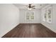 Bright bedroom featuring hardwood floors, neutral walls, a ceiling fan, and windows at 209 E 1St N St, Summerville, SC 29483