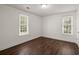 Bedroom showcasing hardwood floors and natural light from two large windows at 209 E 1St N St, Summerville, SC 29483
