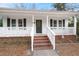 Inviting front porch with white railings, brick foundation, and a dark-colored front door at 209 E 1St N St, Summerville, SC 29483