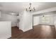 Bright living room featuring an elegant chandelier and hardwood floors leading to the airy living space at 209 E 1St N St, Summerville, SC 29483