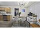 Bright dining area with a modern light fixture, white chairs, wood table, and adjacent kitchen at 214 Terry Ave, Summerville, SC 29485