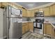 Well-lit kitchen features stainless steel appliances and wood cabinetry at 214 Terry Ave, Summerville, SC 29485