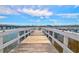 Exterior shot of a wooden dock over the water with white railings and a seating area at the end at 2395 Folly Road # 4H, Folly Beach, SC 29439