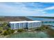 Aerial view of a condo building overlooking a scenic waterfront with a dock and marshland at 2395 Folly Road # 4H, Folly Beach, SC 29439