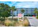 Exterior view of the Twin Rivers Condominiums sign with lush landscaping and plenty of parking at 2395 Folly Road # 4H, Folly Beach, SC 29439