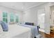 Comfortable bedroom with a blue bed frame, shiplap walls, and an ensuite bathroom view at 27 22Nd Ave, Isle of Palms, SC 29451