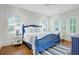 Charming bedroom features a blue bed frame, shiplap walls, and natural light from the windows at 27 22Nd Ave, Isle of Palms, SC 29451