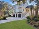 Beautiful two-story home with a three-car garage, surrounded by lush landscaping and palm trees at 27 22Nd Ave, Isle of Palms, SC 29451
