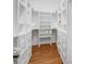 Walk-in closet with custom shelving and drawers for organized storage and hardwood floors at 27 22Nd Ave, Isle of Palms, SC 29451