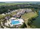 Community clubhouse and pool area from an aerial view, showcasing the large pool, surrounding greenery, and nearby parking at 2784 Hidden Oak Dr, Seabrook Island, SC 29455