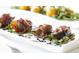 Close-up of figs wrapped in prosciutto on a white plate with balsamic drizzle at 2784 Hidden Oak Dr, Seabrook Island, SC 29455