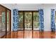 Hardwood floors and sliding glass doors to the balcony with blue patterned curtains at 2784 Hidden Oak Dr, Seabrook Island, SC 29455