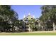 Attractive multi-story home showcasing balconies, mature trees, and manicured lawn at 2784 Hidden Oak Dr, Seabrook Island, SC 29455