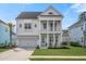Inviting two-story home with a double front porch, white columns, a well-manicured lawn and a two car garage at 2942 Clearwater Dr, Mount Pleasant, SC 29466
