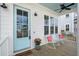 Charming front porch featuring rocking chairs, a 'beach people' mat, and a lovely blue ceiling and door at 2942 Clearwater Dr, Mount Pleasant, SC 29466