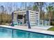 The backyard features a beautiful poolside cabana complete with TV and lounge seating at 2942 Clearwater Dr, Mount Pleasant, SC 29466