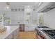 Modern kitchen with stainless steel appliances, white cabinetry, and an island with marble countertops at 301 Hidden Bottom Ln, Daniel Island, SC 29492