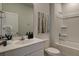 Bright bathroom featuring a shower over tub, white vanity and a large mirror at 305 Tiliwa Street, Summerville, SC 29486