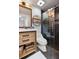 Well-lit bathroom features a modern vanity, stylish mirror, decorative shelving, and a glass-enclosed shower with attractive tile at 377 King St # 203, Charleston, SC 29401
