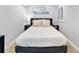 Neutral bedroom with beach painting above the bed, modern decor, and a window shutter at 377 King St # 203, Charleston, SC 29401