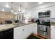 Modern kitchen with stainless steel appliances, white cabinets, granite countertops and a breakfast bar at 377 King St # 203, Charleston, SC 29401