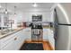 Modern kitchen with white cabinets, granite countertops, stainless steel appliances, and hardwood floors at 377 King St # 203, Charleston, SC 29401