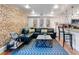 Modern living room featuring exposed brick, comfortable seating, stylish decor, and a view into the kitchen at 377 King St # 203, Charleston, SC 29401