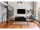 Living space featuring hardwood floors, a spiral staircase, a mounted TV, and ample natural light at 377 King St # 203, Charleston, SC 29401