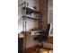 Stylish home office setup with desk, shelving, comfortable chair, and exposed brick wall at 377 King St # 203, Charleston, SC 29401
